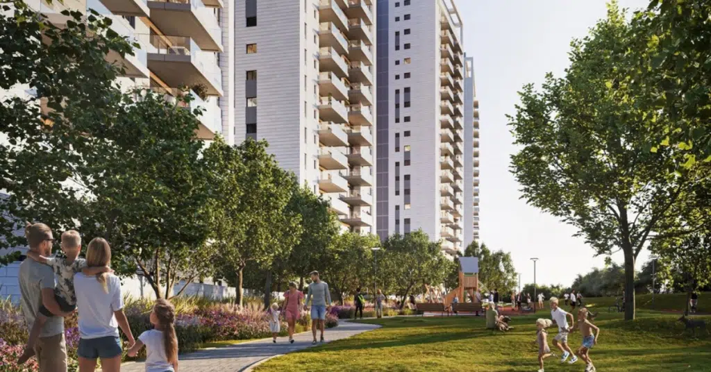 מתחם מגורים חדש עם בניינים מודרניים, פארק ירוק ומשפחות נהנות מבילוי בשטח פתוח.