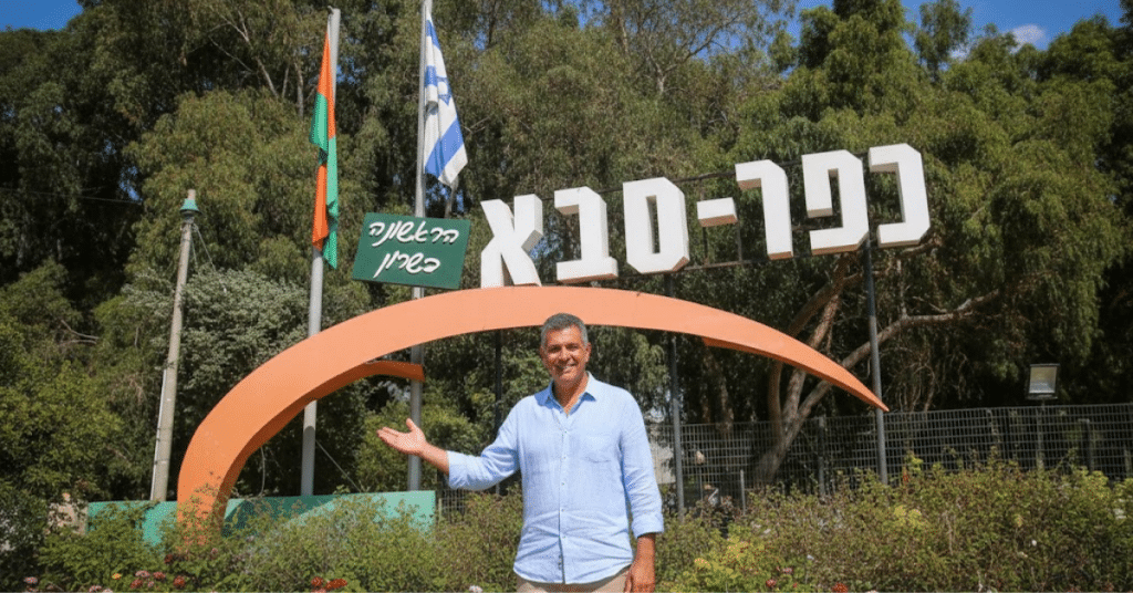 שלט הכניסה לעיר כפר סבא עם דמות מחייכת, המייצגת הזדמנות להשקעה בקרקע פרטית בצפון העיר.